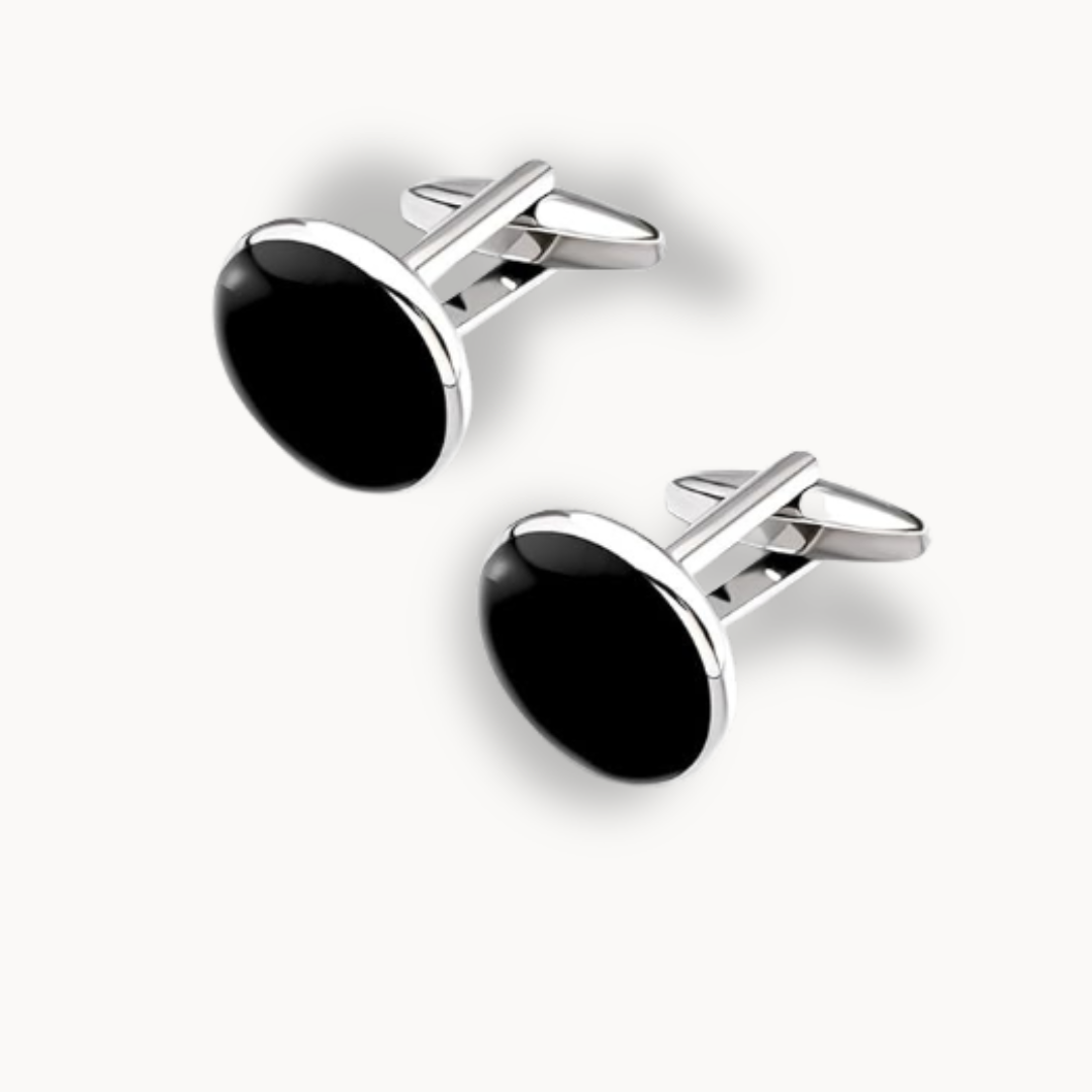 Pair of black cufflinks with silver borders on a white background